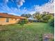 Spacious backyard featuring lush green grass and mature landscaping with a screened-in patio at 206 Memphis Pl, St Cloud, FL 34769