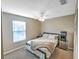 Bedroom showcasing neutral walls, carpet, ceiling fan, and large window providing natural light at 206 Memphis Pl, St Cloud, FL 34769