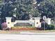 Community entrance sign amid lush landscaping, blooming flowers and greenery at 2203 San Vittorino Cir # 107, Kissimmee, FL 34741