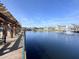 Waterfront view from a wooden pier of a pond featuring a fountain and inviting seating at 2203 San Vittorino Cir # 107, Kissimmee, FL 34741