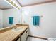 Bathroom showcasing a vanity with ample lighting, a large mirror, and a decorative towel rack at 3039 China Berry Ct, Kissimmee, FL 34746