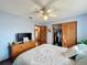 Bedroom featuring wood cabinets with a door to a closet, a TV and comfortable bedding with accent pillows at 3039 China Berry Ct, Kissimmee, FL 34746