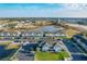 Aerial view shows neighborhood features townhomes, parking, and a scenic pond at 361 Annabelle Way, Davenport, FL 33837