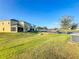 Backyard with green lawn leads to building with patios and parking at 361 Annabelle Way, Davenport, FL 33837