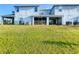Backyard view shows green lawn, screened patio, and back exterior of home at 361 Annabelle Way, Davenport, FL 33837