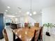 Open-concept dining room adjacent to the kitchen, with a wooden table and stylish chandelier at 361 Annabelle Way, Davenport, FL 33837