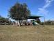 A shady community playground with swings and slides surrounded by green grass and mature trees at 361 Annabelle Way, Davenport, FL 33837
