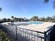 View of the community pool surrounded by a brick patio and wrought iron fencing at 361 Annabelle Way, Davenport, FL 33837