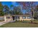 Charming single-story home with tan siding, brown shutters, well-manicured lawn, and mature landscaping at 3827 Anna Dr, Apopka, FL 32703