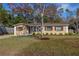 Charming single-story home with a manicured lawn, mature landscaping, and a welcoming entryway at 3827 Anna Dr, Apopka, FL 32703