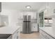 Stylish kitchen showcasing stainless steel refrigerator, white cabinets, marble countertops, and access to porch at 3827 Anna Dr, Apopka, FL 32703