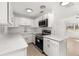 Contemporary kitchen with stainless steel appliances, white cabinets, and a sleek range hood at 3827 Anna Dr, Apopka, FL 32703