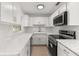 Updated kitchen with white cabinets, marble countertops, stainless steel appliances, and tile backsplash at 3827 Anna Dr, Apopka, FL 32703