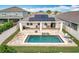 Aerial view of a backyard with a pool, brick-paved pool deck, and a covered patio at 3857 San Isidro Cir, St Cloud, FL 34772