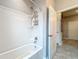 White bathtub and shower with chrome fixtures, and a clear view of the hallway, plus neutral walls and floor at 3857 San Isidro Cir, St Cloud, FL 34772