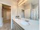Bright bathroom features a double sink vanity, quartz countertop, modern fixtures, and a large mirror at 3857 San Isidro Cir, St Cloud, FL 34772