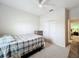 A neutral bedroom is carpeted, has a fan, and a view to another bedroom via a door at 3857 San Isidro Cir, St Cloud, FL 34772
