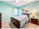 Cozy bedroom with light blue walls, a window with blinds, and a comfortable bed at 3857 San Isidro Cir, St Cloud, FL 34772