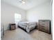Neutral bedroom boasts carpet floors, a fan, a window, and rustic wood furniture at 3857 San Isidro Cir, St Cloud, FL 34772