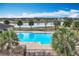 Community pool and clubhouse overlooking a pond with palm trees at 3857 San Isidro Cir, St Cloud, FL 34772