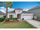 Charming single-story home with a well-manicured lawn, a palm tree, and a two-car garage at 3857 San Isidro Cir, St Cloud, FL 34772