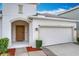 Close-up of the home showcasing the two-car garage and covered front entrance at 3857 San Isidro Cir, St Cloud, FL 34772