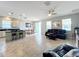 Open-concept living space connecting the kitchen, dining area, and living room, featuring tile flooring and neutral decor at 3857 San Isidro Cir, St Cloud, FL 34772
