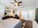 Main bedroom showcasing dark wood floors, a ceiling fan, and a glimpse into the ensuite bathroom at 3857 San Isidro Cir, St Cloud, FL 34772