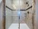 Close-up of a shower with glass doors, tiled walls with decorative accents, and a shower head at 3857 San Isidro Cir, St Cloud, FL 34772