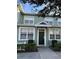 Charming townhouse with a dark green front door, white trim, and manicured landscaping at 4010 San Gallo Dr # 105, Kissimmee, FL 34741