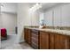 Bathroom featuring a double sink vanity with granite countertops and a doorway view to an adjacent bedroom at 561 Lasso Dr, Kissimmee, FL 34747