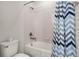 Bright bathroom featuring a shower-tub combo with a blue chevron shower curtain and a modern toilet at 561 Lasso Dr, Kissimmee, FL 34747