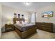 Bedroom featuring a queen bed, dresser and mounted TV with natural light and neutral decor at 561 Lasso Dr, Kissimmee, FL 34747