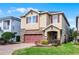 Charming two-story home with brick driveway, stone accents, two-car garage and manicured landscaping at 561 Lasso Dr, Kissimmee, FL 34747