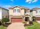Charming two-story home with brick driveway, stone accents, two-car garage and manicured landscaping at 561 Lasso Dr, Kissimmee, FL 34747