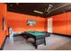 Game room with orange walls, a black ceiling, a pool table, and a mounted TV at 561 Lasso Dr, Kissimmee, FL 34747