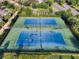 Aerial view of two well-maintained tennis courts with green and blue surfaces, ready for a match at 561 Lasso Dr, Kissimmee, FL 34747