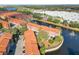 Aerial view of community townhomes beside a lake featuring fountains, showcasing a well-maintained and desirable neighborhood at 6109 Metrowest Blvd # 105, Orlando, FL 32835
