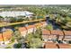 A beautiful community is pictured from above with well-kept townhomes surrounding a pond with fountain features at 6109 Metrowest Blvd # 105, Orlando, FL 32835