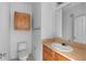 A well-lit bathroom with a vanity, sink, mirror, toilet, and a storage cabinet at 6109 Metrowest Blvd # 105, Orlando, FL 32835