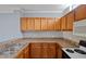 Kitchen with wood cabinets and tile backsplash at 6109 Metrowest Blvd # 105, Orlando, FL 32835