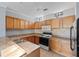 Functional kitchen featuring wood cabinetry, tile backsplash, and modern appliances at 6109 Metrowest Blvd # 105, Orlando, FL 32835