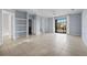 Spacious living room with large sliding glass door, tile flooring, and built-in shelving at 6109 Metrowest Blvd # 105, Orlando, FL 32835
