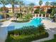 A pristine community pool is surrounded by lush landscaping, lounge chairs, and shaded cabanas for ultimate relaxation at 6109 Metrowest Blvd # 105, Orlando, FL 32835