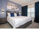 Comfortable bedroom featuring a queen-size bed, custom lighting, and a lake art piece at 750 Pebble Beach Dr, Davenport, FL 33896