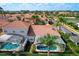 Aerial view of a beautiful home with a screened pool in a lush community featuring terra cotta rooftops at 802 Brunello Dr, Davenport, FL 33897