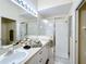 Bright bathroom features a double vanity with a large framed mirror and a glass-enclosed shower at 802 Brunello Dr, Davenport, FL 33897