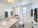 Clean bathroom featuring a shower-tub combo, light beige cabinets, and neutral decor for a soothing experience at 802 Brunello Dr, Davenport, FL 33897