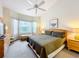 Bright bedroom with a large bay window, ceiling fan, and neutral carpeting provides a cozy atmosphere at 802 Brunello Dr, Davenport, FL 33897