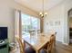 Sunlit dining area features a wooden table and chairs with views of the sparkling pool at 802 Brunello Dr, Davenport, FL 33897